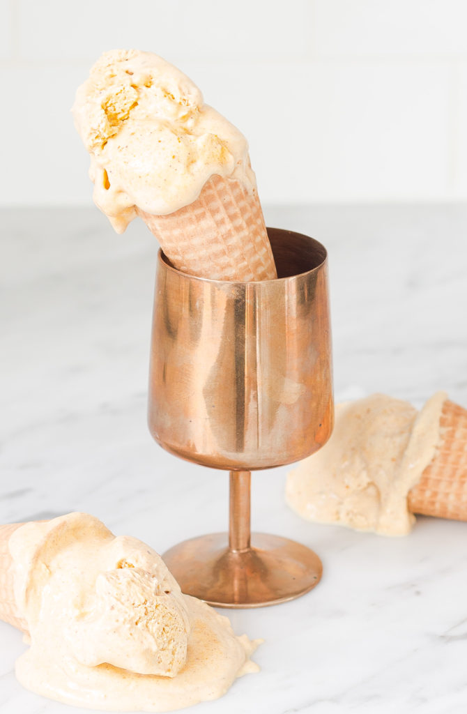 pumpkin ice cream in ice cream cone propped in a copper goblet sitting on counter. 