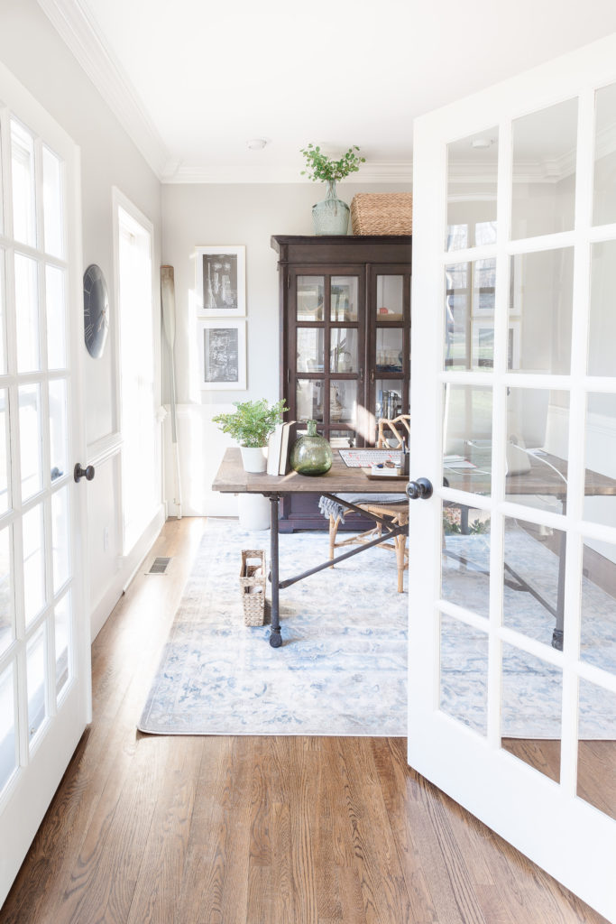 Home office with desk, rug, bookcase and pictures on the wall